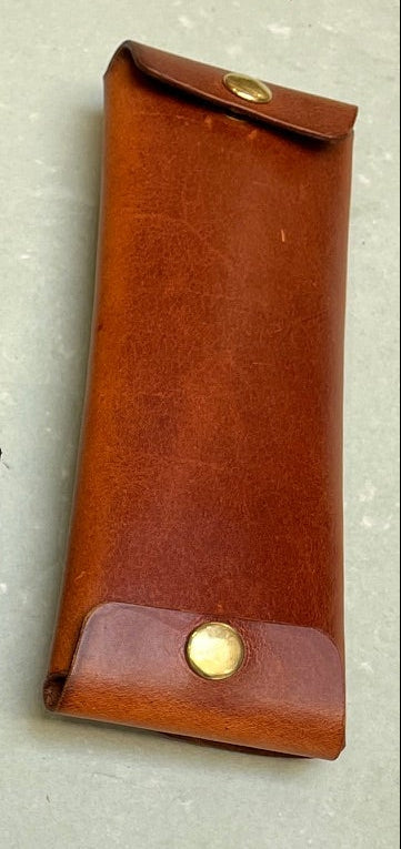 Collection of leather pouches and wallets on a light background