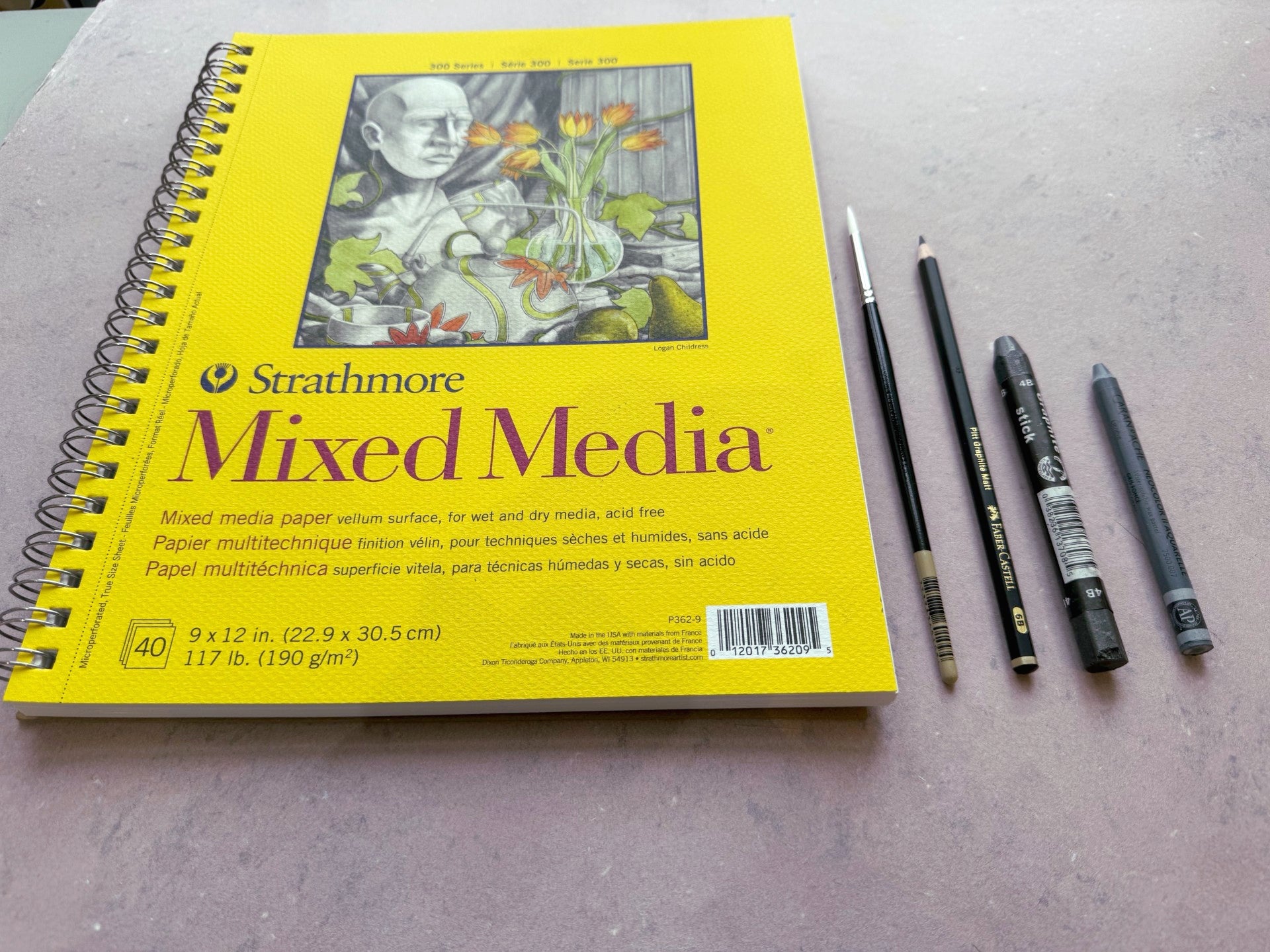 Strathmore Mixed Media paper pad with art supplies on a gray surface